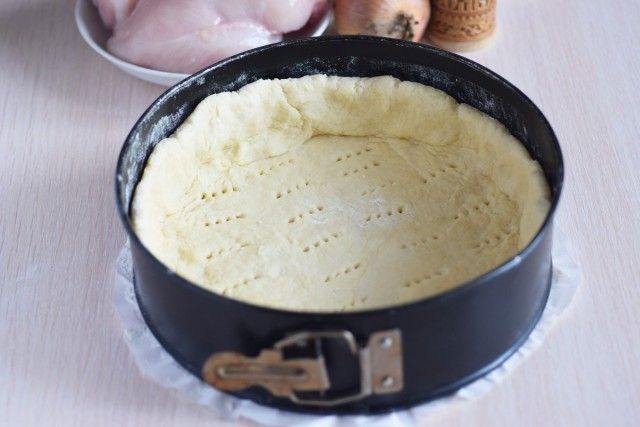 Переносимо на підготовлену форму пласт з тіста і формуємо каркас для пирога, наколює його виделкою