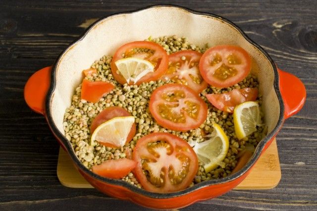 Рівномірно розподіляємо сочевицю і викладаємо зверху помідори і лимон